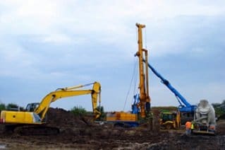 Excavator and drilling rig working on a construction site – selling a site preparation business in Florida
