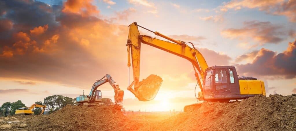 Excavators digging at a construction site at sunset – selling an excavation business in Florida
