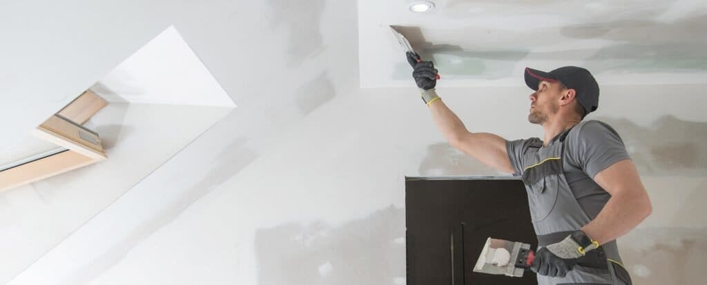 Drywall contractor smoothing joint compound on a wall – selling a drywall contractor business in Florida