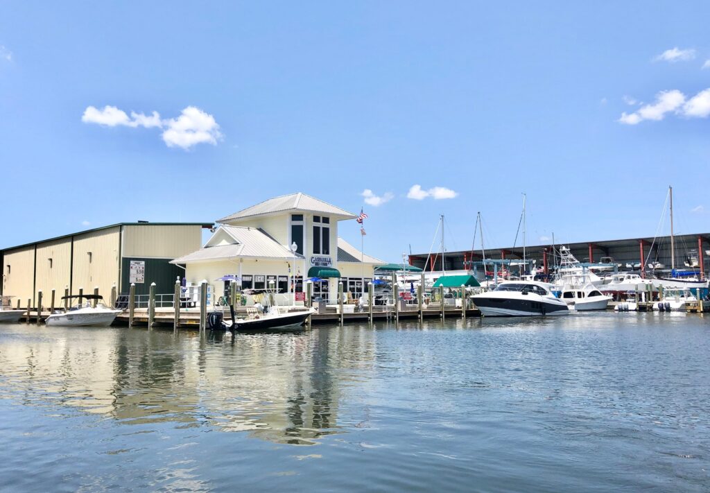 Marina in Port Charlotte, Florida, featuring a waterfront building, boats docked at the pier, and a clear blue sky, illustrating the area's coastal appeal and economic growth.