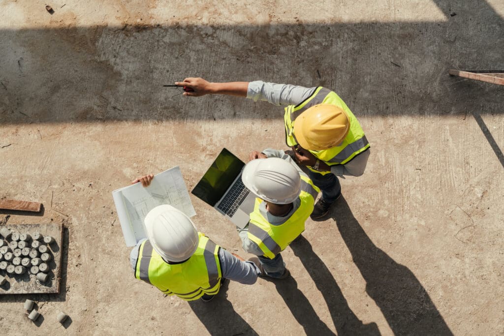 Civil engineer inspecting a construction site with a tablet and blueprint &ndash; selling a concrete contractor business in Florida