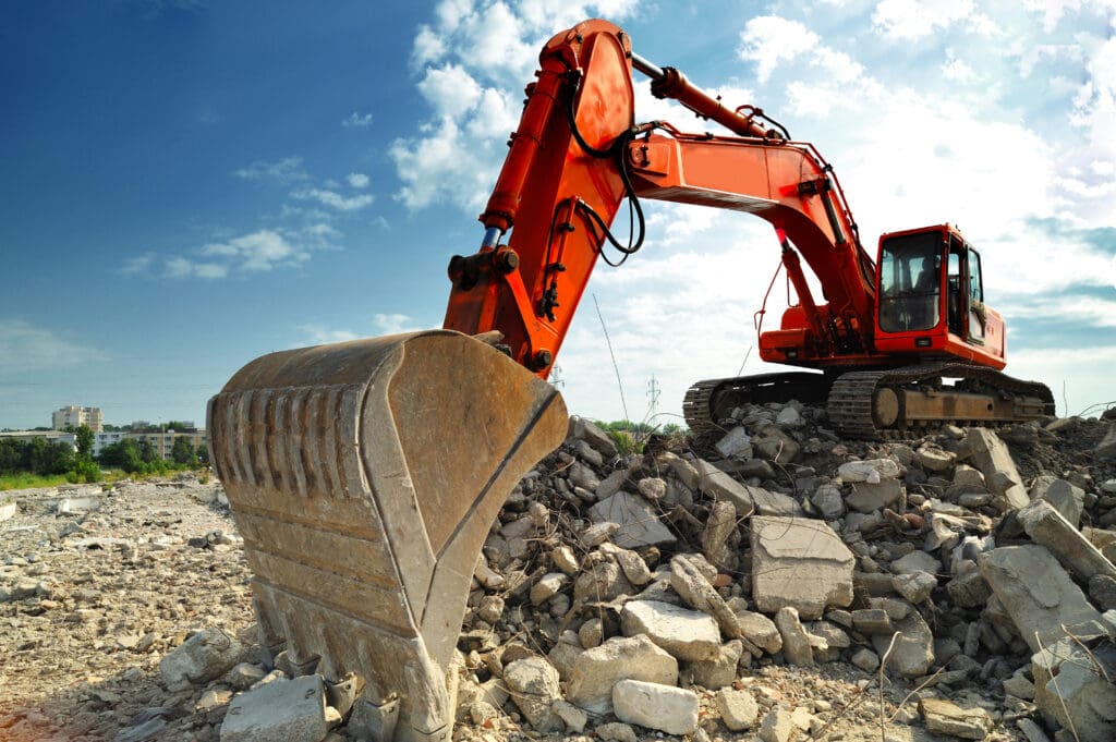 Excavator clearing concrete rubble on a demolition site – selling a demolition business in Florida