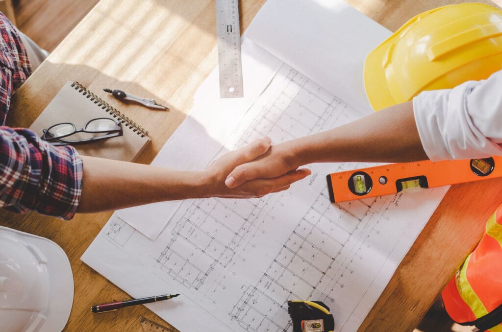 Construction workers shaking hands after a meeting – selling a general contractor business in Florida