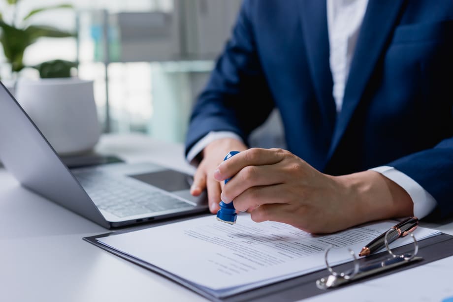 Business owner stamping an approved contract – selling a specialty contracting business in Florida